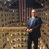 Omar smiling in front of a hotel balcony